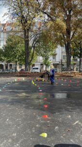 Un groupe d'enfants, joue sous les arbres d’automne en traversant un parcours de cônes colorés